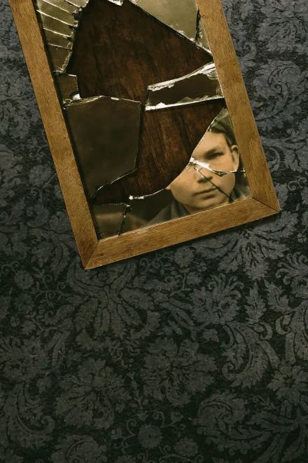 Photomontage of a boy reflected in a broken mirror